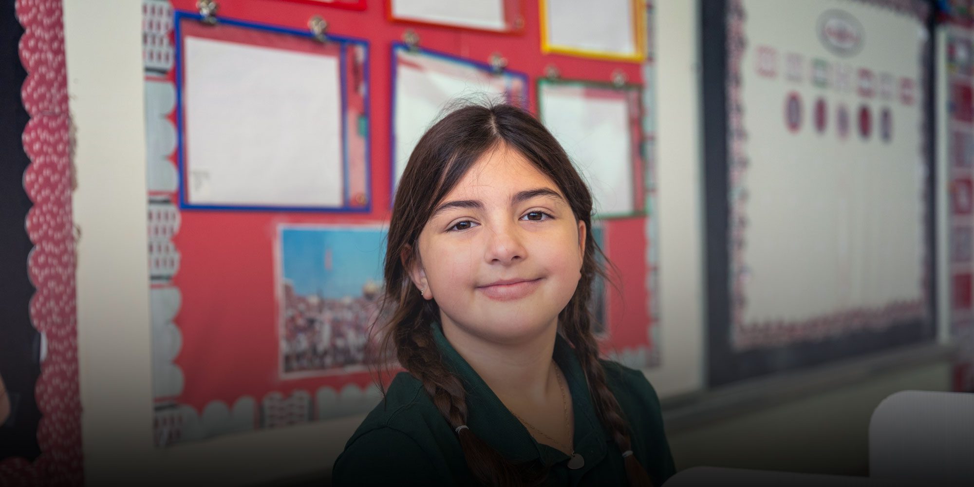Student smiling sitting at desk